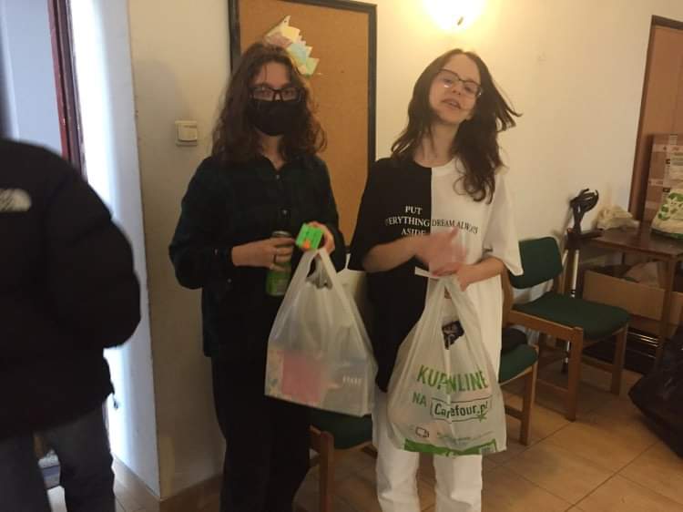 Na zdjęciu widać dwie wolontariuszki, które trzymają potrzebne produkty. 