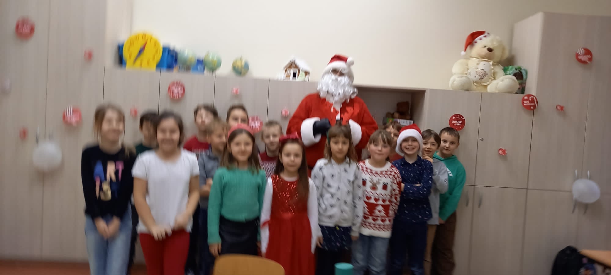 Święty Mikołaj z dziećmi pozują do zdjęcia.