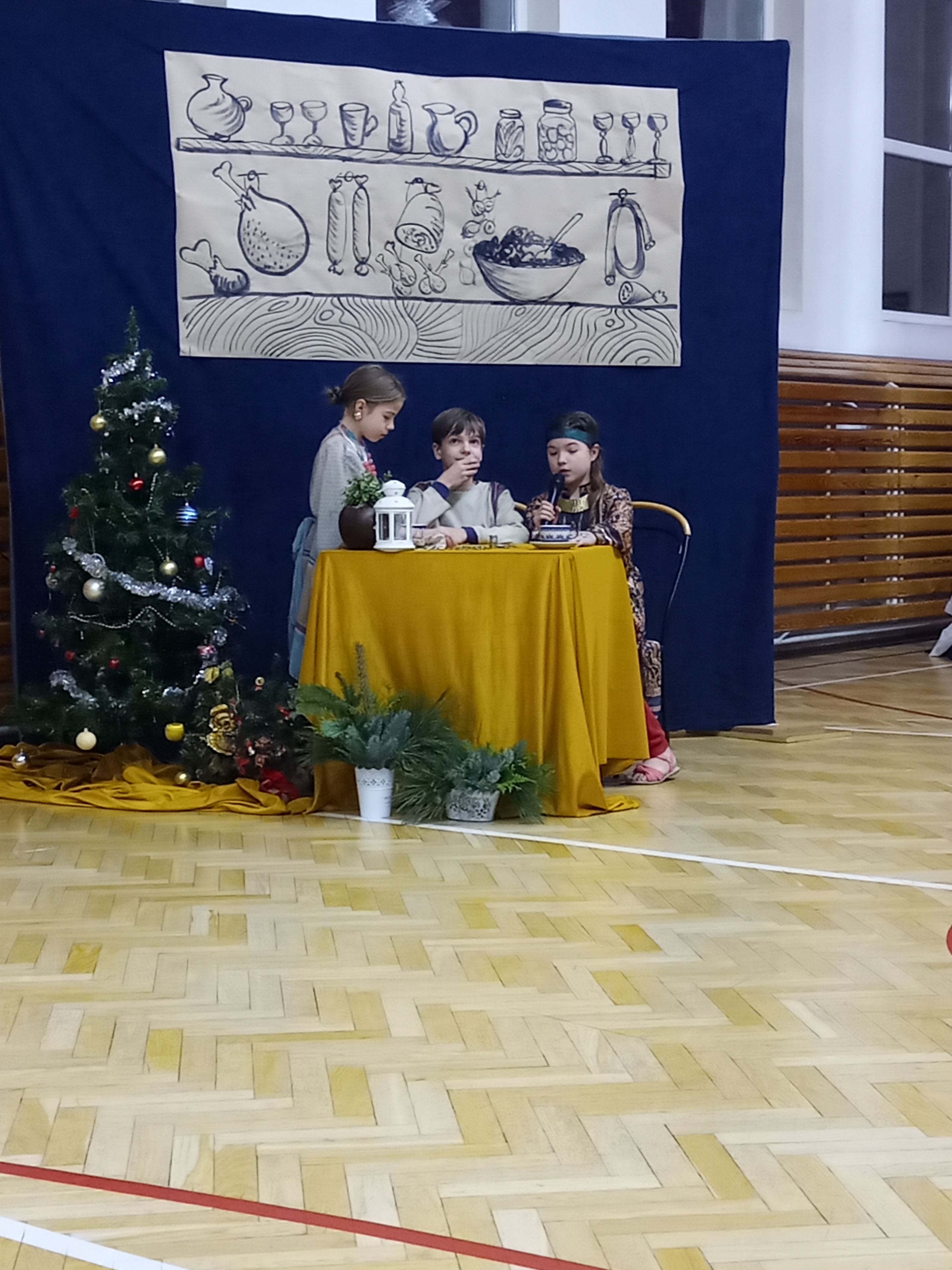Troju dzieci siedzi przy stoliku.