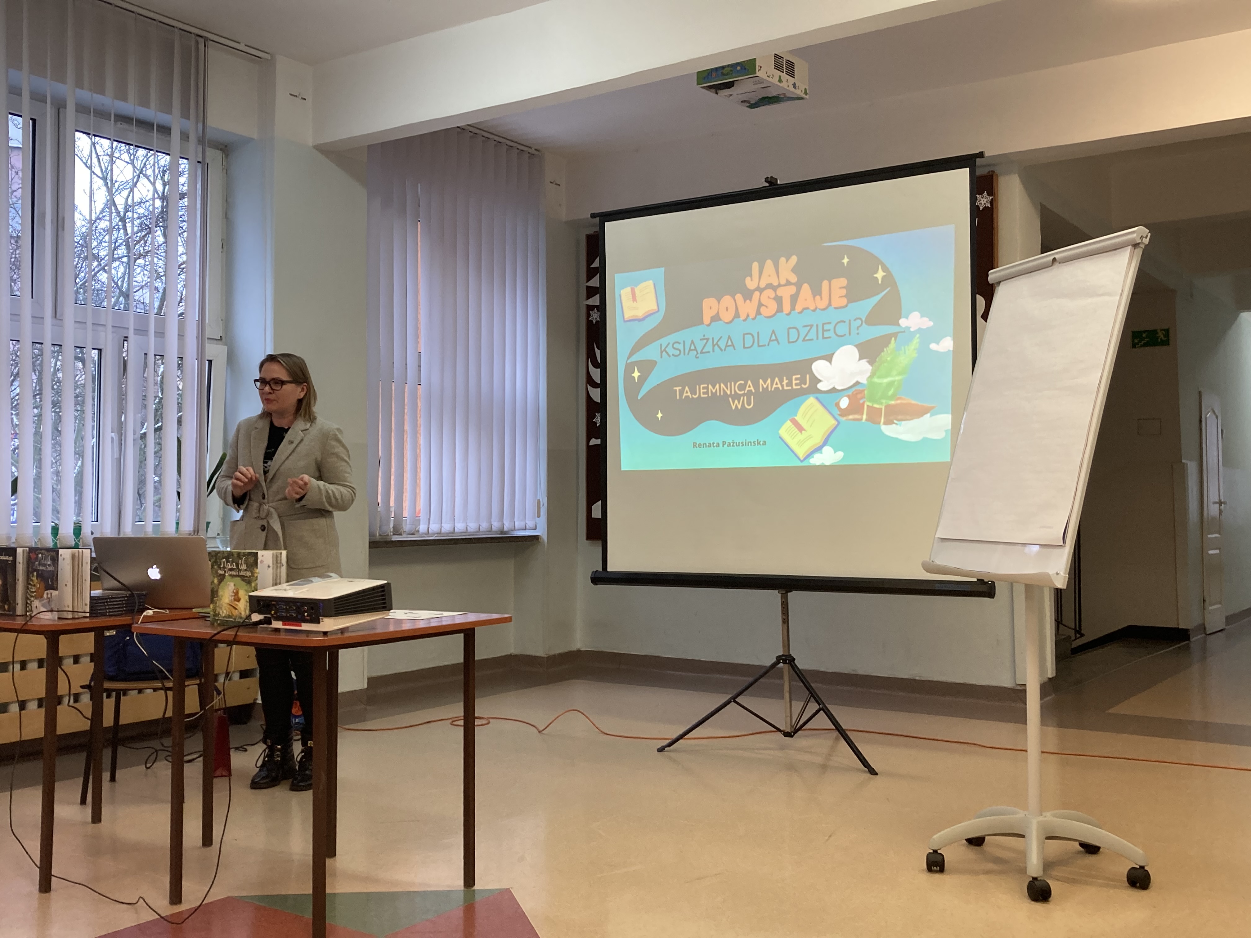 Pisarka, Pani Renata Pażusinska" przedstawia dzieciom prezentację pod tytułem "Jak powstaje książka dla dzieci".