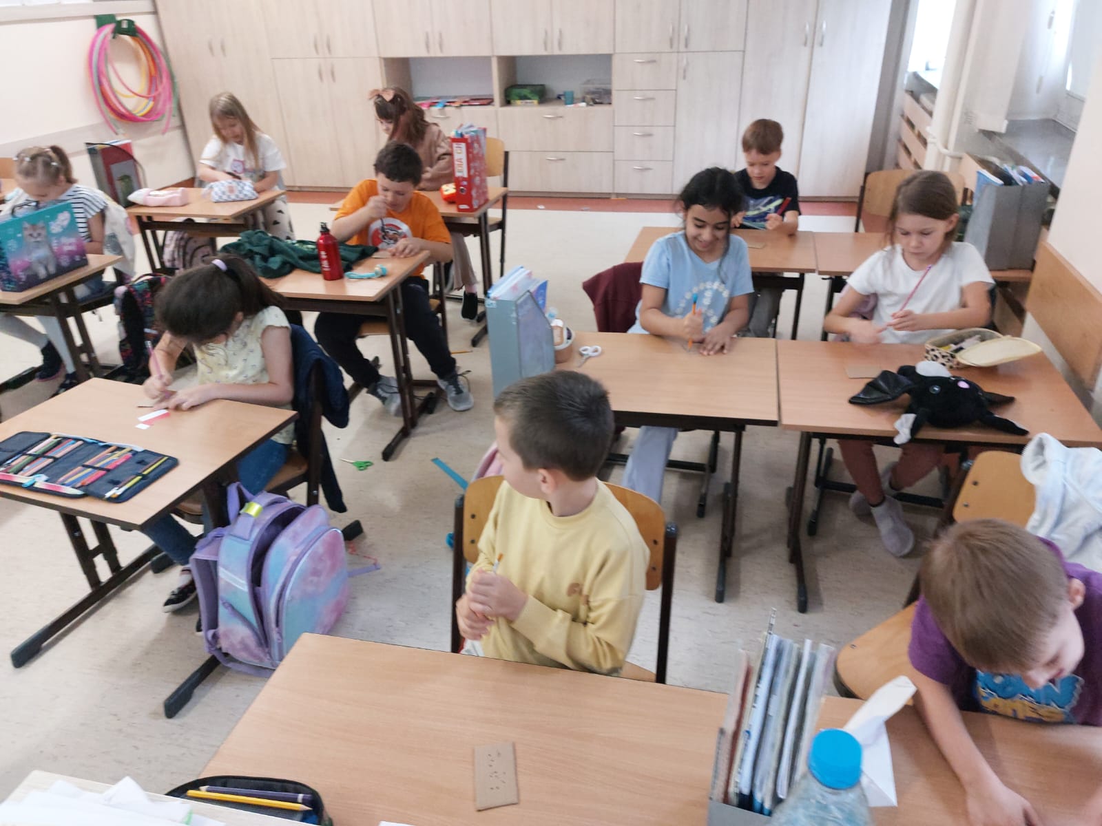 Uczniowie klasy 2a siedzą przy stolikach.