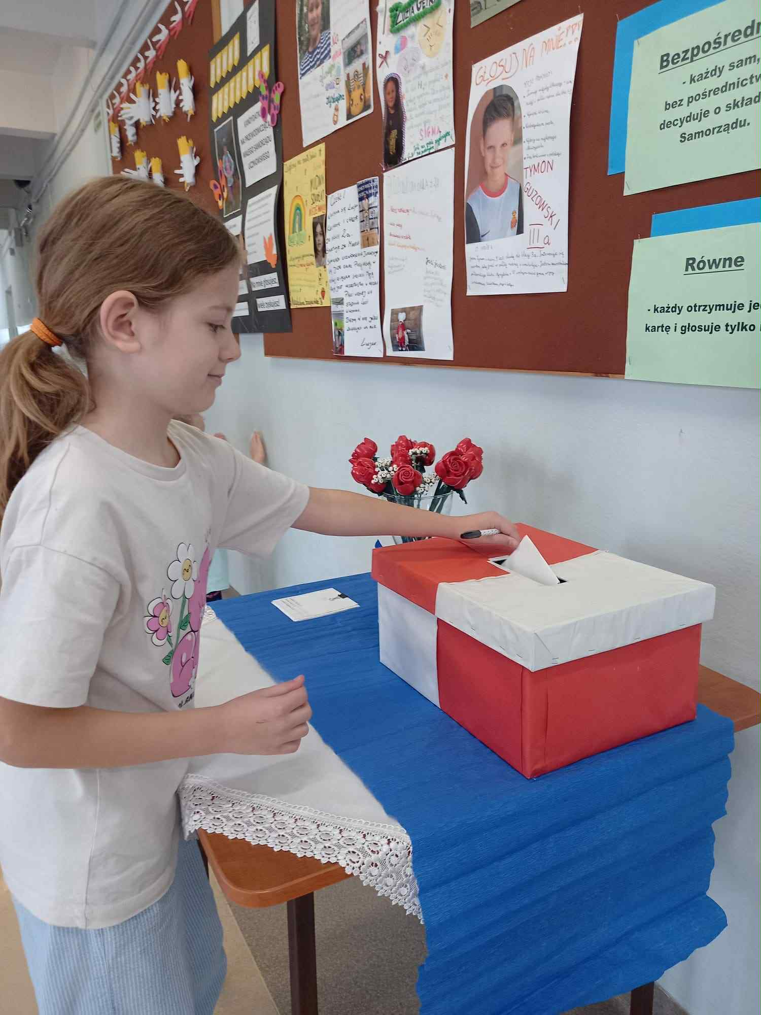 Dziewczynka wrzuca głos do urny.
