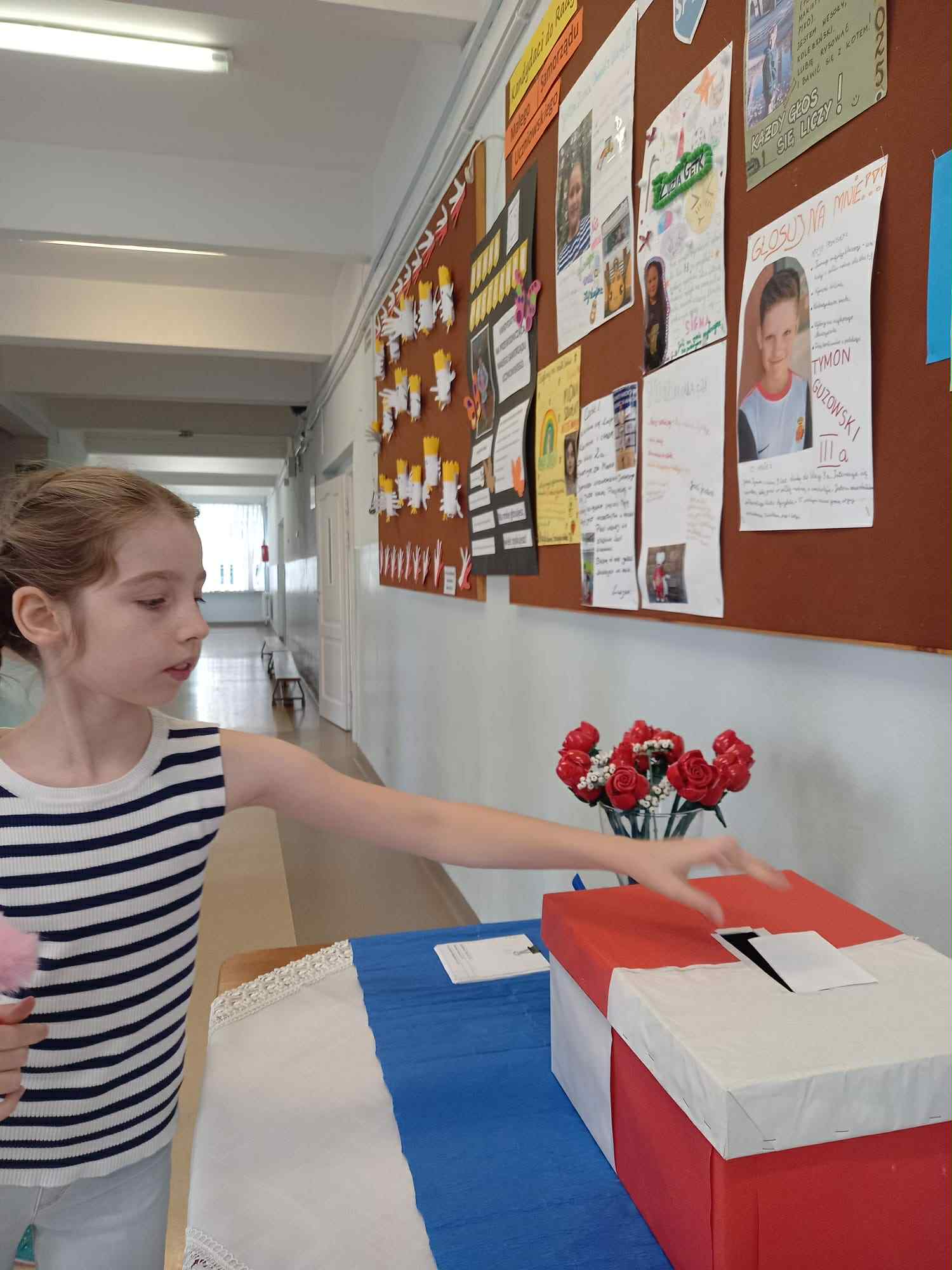 Dziewczynka wrzuca głos do urny.