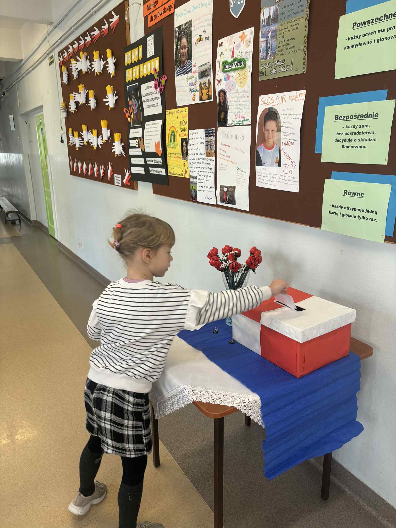 Dziewczynka wrzuca głos do urny.