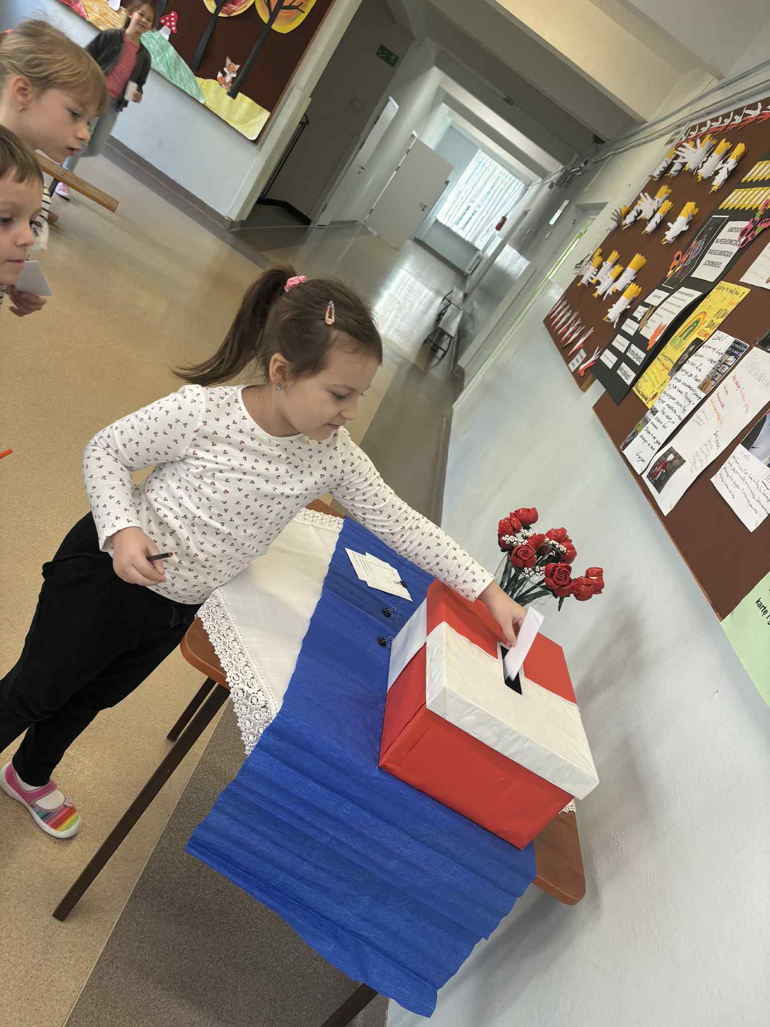 Dziewczynka wrzuca głos do urny.