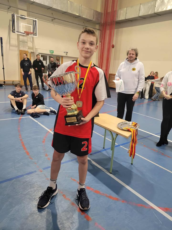 Chłopiec w rękach trzyma puchar.