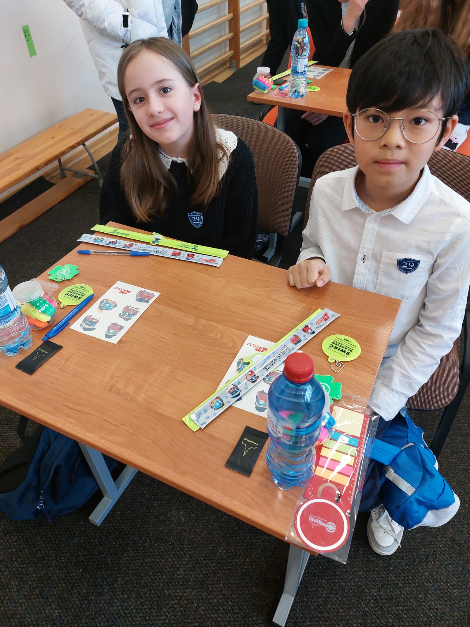 Uczniowie siedzą przy stoliku.