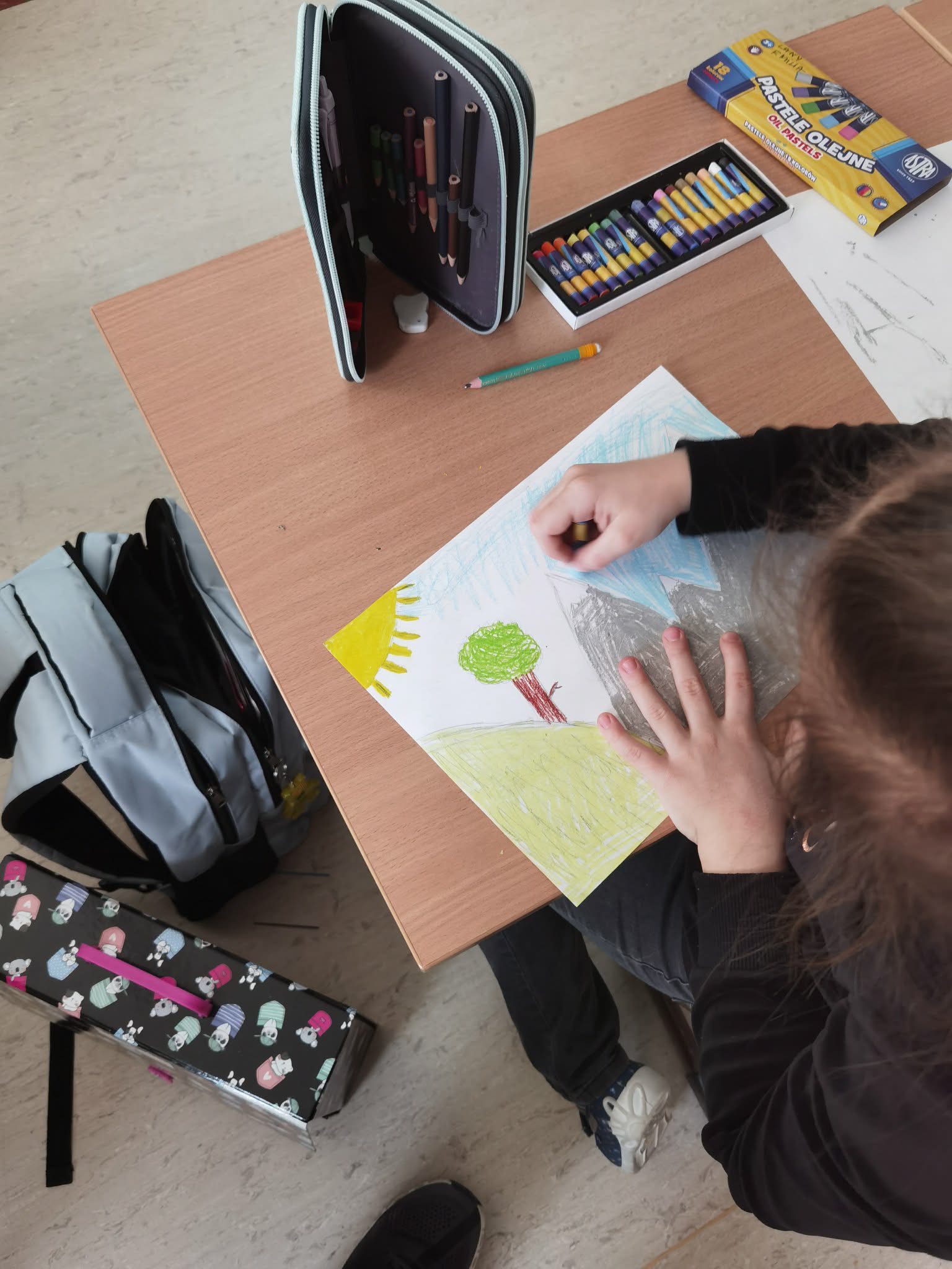 Uczennica maluje farbami.