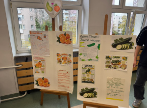 Na zdjęciu widać dwie duże plansze edukacyjne przygotowane przez uczniów, poświęcone zdrowemu odżywianiu i właściwościom warzyw oraz owoców.