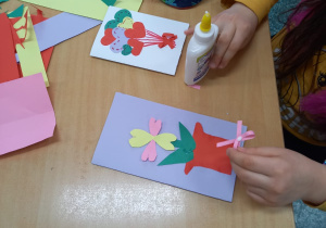 Dzieci wyklejają kolorowe walentynki.