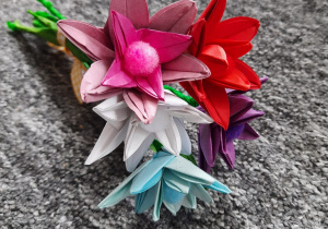 Fotografia przedstawia bukiet kolorowych kwiatów wykonanych techniką origami. Autorka: Amelia Markiewicz kl. 3b.