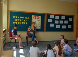 Dzieci z klas 2-3 słuchają wywiadu z panią bibliotekarką.