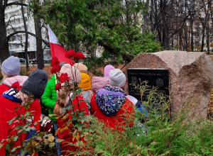 Dzieci pod głazem Jerzego Gawina, porucznika AK poległego w walkach powstańczych na Czerniakowie.