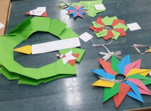 Na zdjęciu widać ozdoby świąteczne z papieru ( gwiazdki, choinki, bombki) wykonane techniką origami.