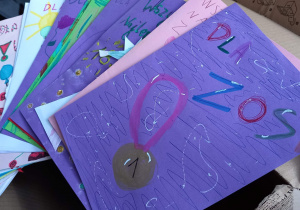 Na stole znajdują się kolorowe kartki wykonane przez uczniów naszej szkoły.