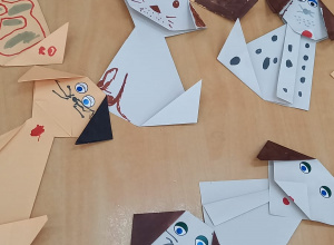Na stole leżą papierowe pieski wykonane techniką origami.