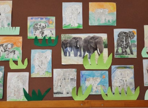 Na tablicy wiszą prace dzieci - słonie wyklejone z szarych gazet.