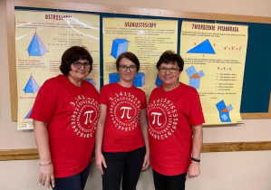 Obok siebie stoją trzy panie matematyczki w czerwonych koszulkach z narysowaną liczbą Pi i jej rozszerzeniem.