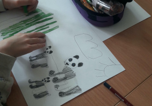 Uczeń rysuje rodzinę niedźwiedzi.