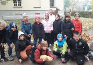 Dzieci stoją przed budynkiem Muzeum Łowiectwa i Jeździectwa w Łazienkach Królewskich.