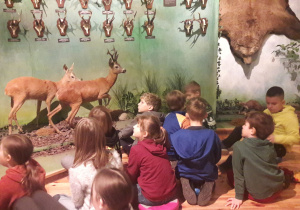 Dzieci oglądają modele zwierząt.