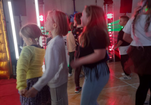 Dzieci w trakcie zabawy andrzejkowej przy muzyce na sali gimnastycznej.