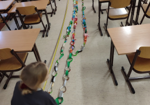 Uczniowie rozkładają łańcuchy na podłodze.