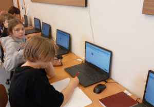 Uczniowie wykonują zadania komputerowe w ramach programu zeszyt.online.