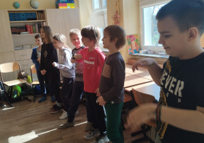 Uczniowie ustawieni obok siebie uczą się kroków poloneza.