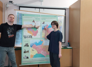 Laureat konkursu historycznego z nauczycielem historii wskazują miejsca na mapie.