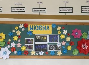 Kwiaty i reprodukcje wiosennych pejzaży zamieszczone na tablicy w sali polonistycznej.