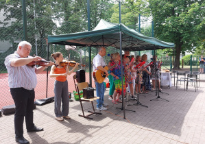 Członkowie zespołu muzycznego grają i śpiewają w czasie pikniku. fot. p. K. Sobczyk