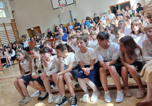 Uczniowie siedzą na ławkach. W głębi sali zgromadzili się rodzice. fot. K. Sobczyk