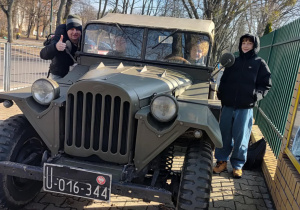 Na pierwszym planie znajduje się samochód wojskowy. Na miejscu kierowcy siedzi chłopiec. Obok niego siedzi koleżanka. Po lewej i prawej stronie samochodu stoi nuczyciel i chłopiec. fot. Łukasz Pawłowski