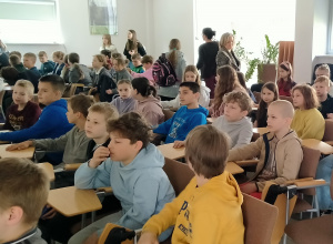 Uczniowie siedzą na krzesłach,