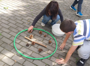 Dzieci trafiają szyszkami i "oszczepem" do celu.