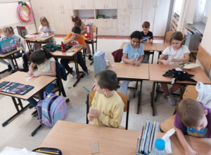 Uczniowie z klasy 2a siedzą przy stolikach.