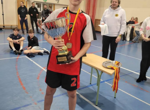 Chłopiec w rękach trzyma puchar.