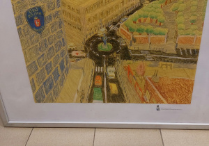 Praca konkursowa „Bezpiecznie na drodze ze Strażą Miejską” wykonana przez Aleksandra. Praca przedstawia rondo, po którym poruszają się pojazdy. Na środku stoi strażnik i pilnuje bezpieczeństwa. W tle widać budynki, drzewa.