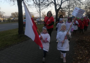 Dziewczynka niesie flagę Polski.