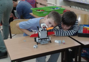 Chłopcy dbają o szczegóły podczas konstruowania robota.
