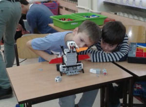 Chłopcy dbają o szczegóły podczas konstruowania robota.